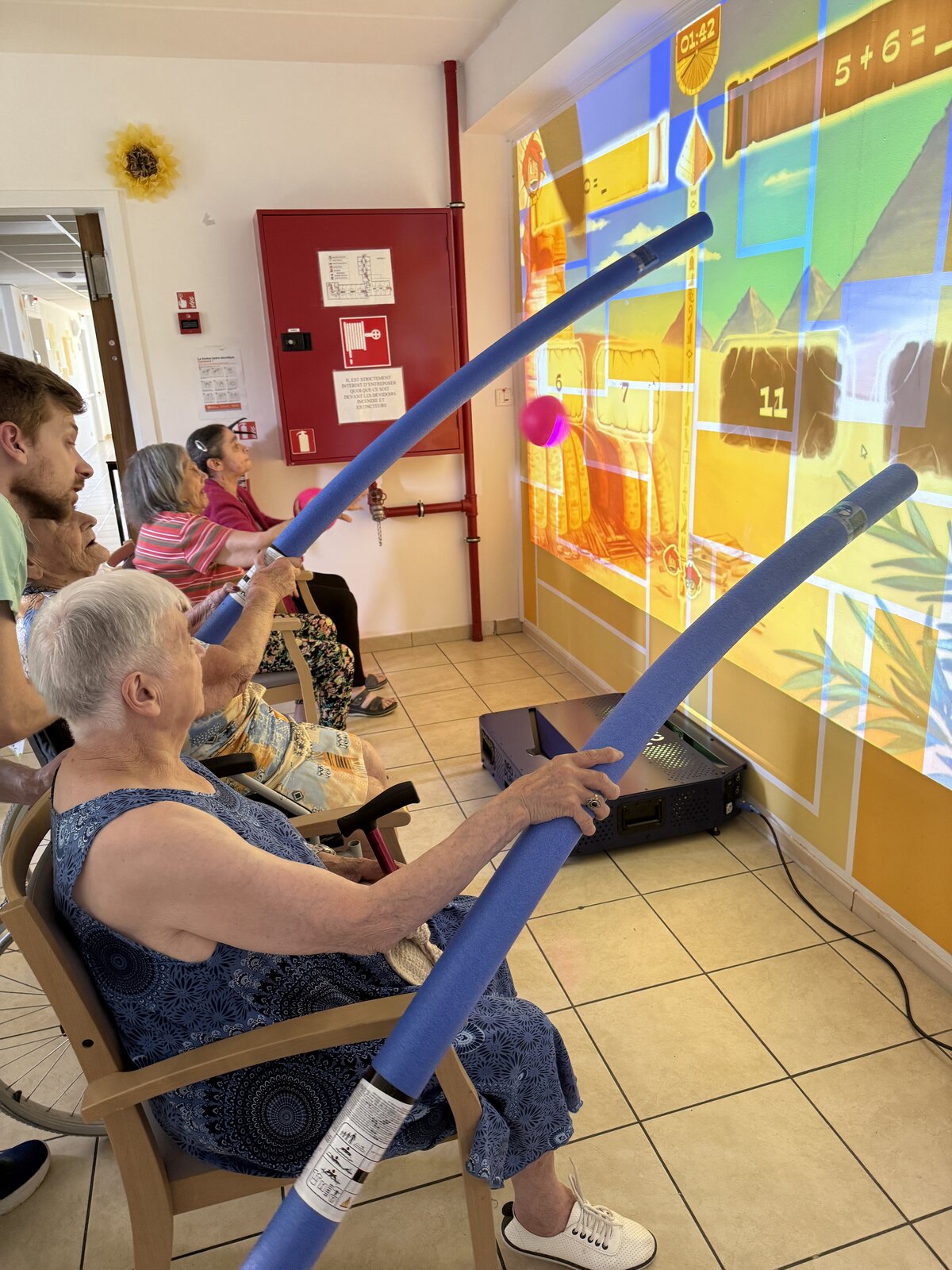 Deux résidentes concentrées sur un jeu projeté sur le mur